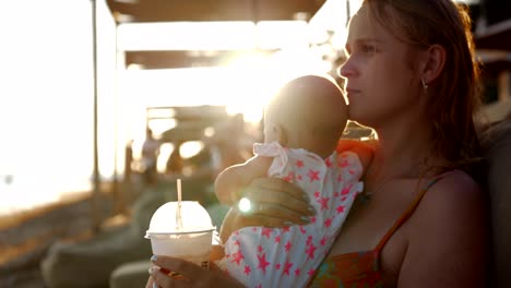 Mutter-mit-Baby-im-Sommerurlaub-am-Meer