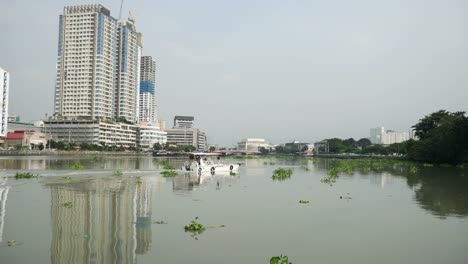 Fluss,-Boot-und-Gebäude-in-Manila