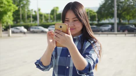 Hermosa-mujer-joven-hablando-con-sus-amigos-con-teléfono-inteligente-portible