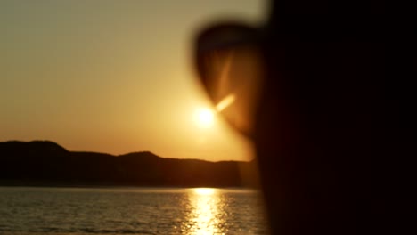 Silhouette-Of-Woman-Watching-Golden-Sunset-At-Beach