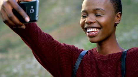 Mujer-tomando-selfie-con-teléfono-móvil-en-el-campo-4k