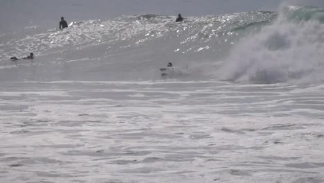 Muchos-surfistas-en-el-océano-azul-de-la-onda,-Marruecos