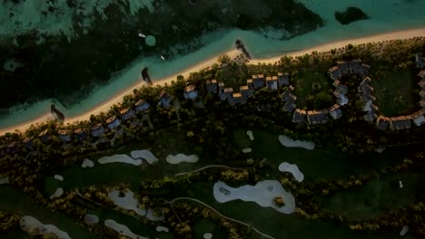 Tropical-island-with-houses-on-the-coast,-aerial-view