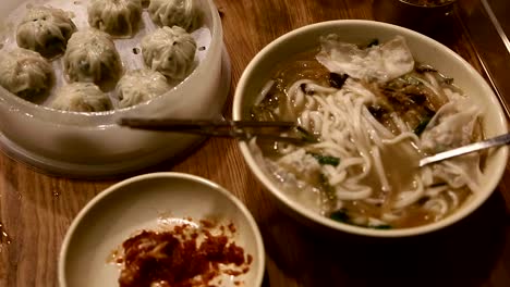 Pan-down-upclose-shot-of-Korean-dumplings-and-noodle-dish