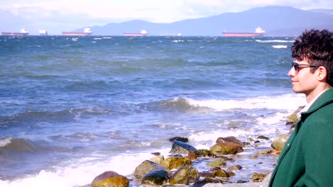 Man-sitting-on-beach-on-a-sunny-day-4k