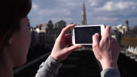 Frau-Tourist-nimmt-Pictureson-auf-Smartphone-in-Brüssel-Belgien