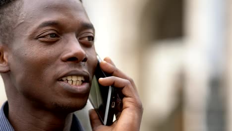 Relaxed-american-african-young-man-talking-by-phone--close-up