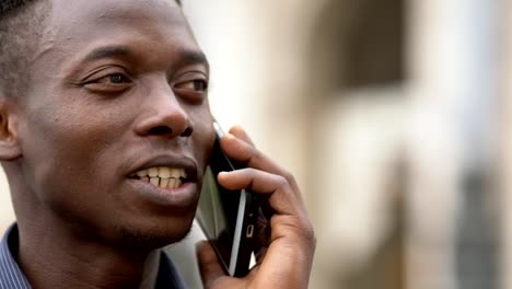 Tranquilo-americano-africano-joven-hablando-por-teléfono-cierre-para-arriba