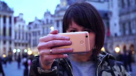 Lady-Tourist-fotografiert-am-Grand-Place-in-Brüssel,-Belgium.slow-Bewegung.-Dolly-Zoom-Effekt