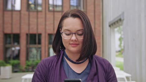 Young-Lady-wearing-Glasses-Using-Phone-in-Town