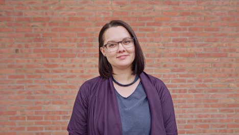 Young-Lady-Smiling-against-a-Brick-Wall-Background