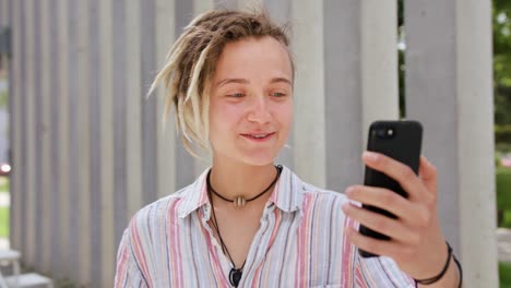 Young-Lady-with-Modern-Hairstyle-Using-Phone-in-Town