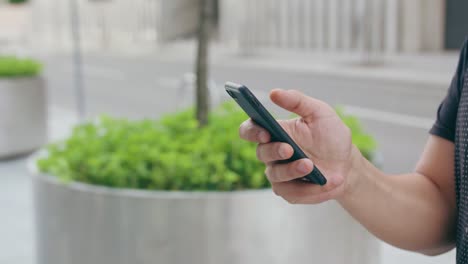 Mano-de-joven-teléfono-al-aire-libre