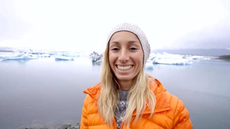 Retrato-de-mujer-de-pie-junto-a-la-laguna-glaciar-en-Islandia,-la-gente-viaja-concepto-de-descubrimiento-del-norte