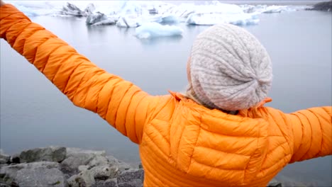 Cámara-lenta-chica-estirados-brazos-en-Laguna-de-glaciar-en-Islandia