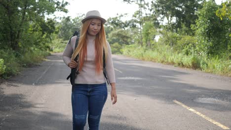 Traveler-woman-backpacker-hitchhiking-on-the-road-and-walking.