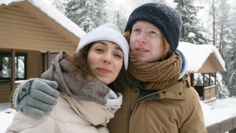 Freudiges-paar-Embracing-und-Winter-Natur-im-Freien-genießen