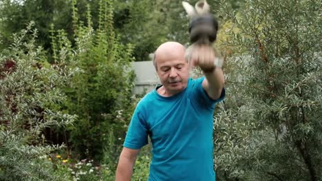 Senior-caucasian-man-training-arms-doing-special-exercise-with-weight.