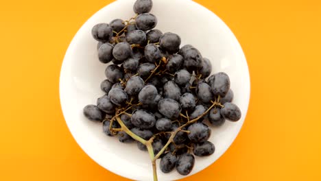 Dark-grapes-in-plate-rotating.