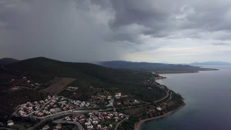 Aerial-view-of-sea-and-coast-with-houses-on-overcast-day.-Trikorfo-Beach,-Greece