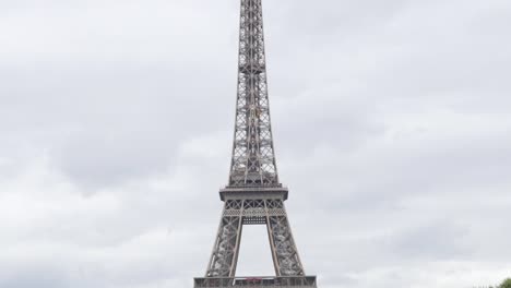 Slow-tilting-on-Eiffel-tower-and-symbol-of-France-in-front-of-cloudy-sky