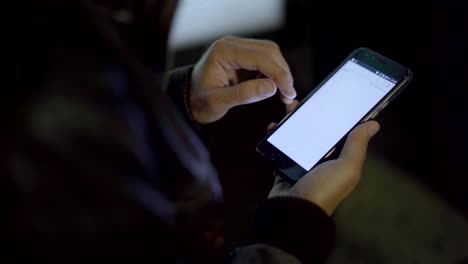 Adult-man-networking-smartphone-in-night-city