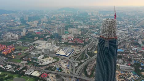 puesta-de-sol-hora-Kuala-Lumpur-centro-megatall-construcción-antena-panorama-timelapse-4k-Malasia