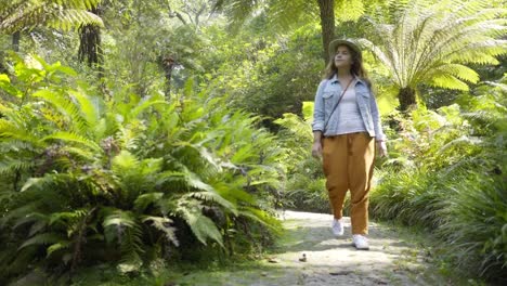 Young-lady-walking-along-park-path