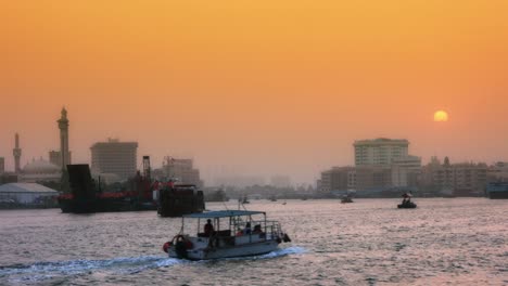 Locked-On-shot-of-a-ferry-boat-moving-on-river-at-dusk,-Dubai,-United-Arab-Emirates