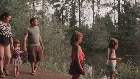 Familia-caminando-por-un-sendero-en-el-parque-junto-al-agua