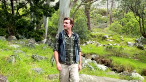 Smiling-man-hiking-through-a-forest