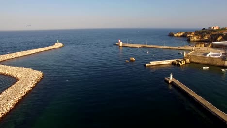 Seagulls-over-harbour-and-fort-of-Lagos,-Algarve,-Portugal-aerial-view