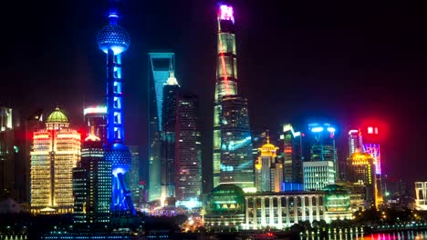 Night-time-lapse-of-the-Huangpu-river,-the-Pudong-financial-business-district,-and-the-Bund,-Shanghai-skyline,-urban-China