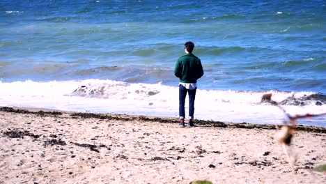 Hombre-de-pie-en-la-playa-en-un-día-soleado-4k