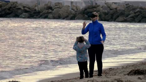 Madre-e-hijo-divertirse-con-gafas-VR-en-la-orilla