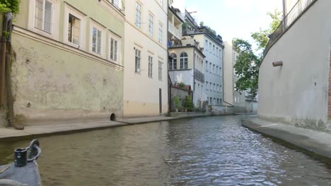 Eine-Motorboot-fährt-entlang-der-Moldau.-Ein-Touristenboot-fährt-entlang-der-Kanäle-des-Flusses-in-Prag.-Touristen-sehen-Sie-die-Sehenswürdigkeiten-vom-Boot-(Ansicht-von-der-ersten-Person).