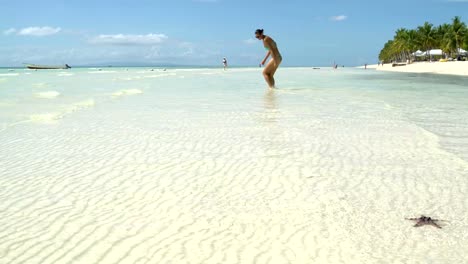 A-woman-walks-into-the-sea-and-sits-down