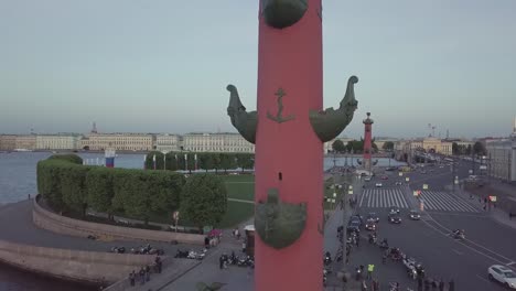 Red-Rostral-Columns-and-Old-Saint-Petersburg-Stock-Exchange-on-Spit-Strelka-of-Vasilievsky-Island.-Neva-river.-Day-traffic.-summer-day,-dramatic-mood.-FullHD-drone-aerial-footage.-Slow-Drift.-panorama