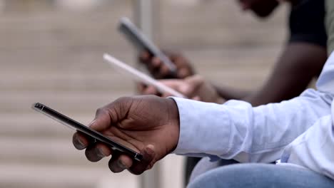 Black-and-white-hands-typing-on-smartphones-in-the-city