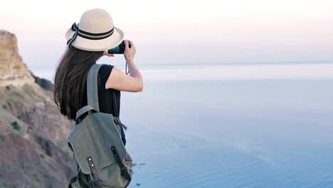 Attraktive-junge-Frau-Fotograf-in-Hut-nehmen-Foto-oder-Video-mit-professioneller-Kamera