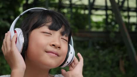 Little-girl-listens-to-music-from-headphone-and-good-feeling