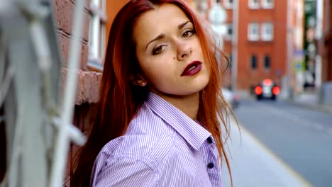 Portrait-of-sexy-woman-with-long-red-hair,-in-the-city.