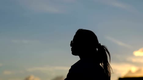 Hermosa-mujer-con-pelo-largo-rojo-en-la-azotea.-Puesta-de-sol-de-luz,-viento