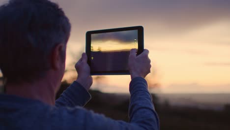 Mann-fotografieren-schönen-Sonnenuntergang-durch-Digital-Tablette-4K