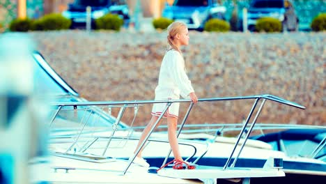 Beautiful-little-girl-on-the-deck-of-a-yacht-looks-somewhere-and-thinks-about-something