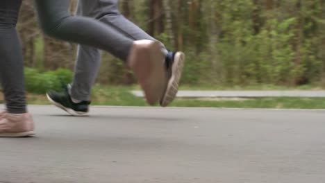 Unrecognizable-People-Jogging-along-Pavement