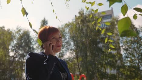 Happy-redhead-woman-calling-and-talking-on-phone