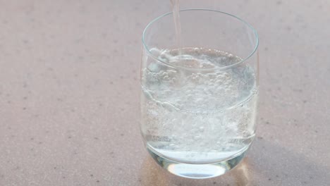 kohlensäurehaltigem-Mineralwasser-füllt-ein-Glas