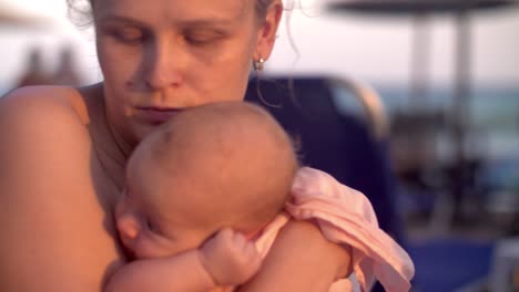 Mamá-con-bebé-en-la-playa-al-atardecer