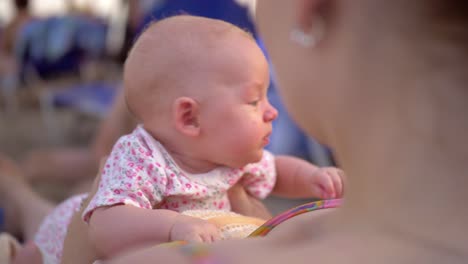 Mother-with-baby-daughter-relaxing-at-the-beach